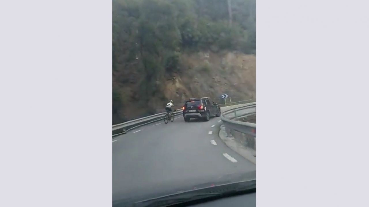 Un cycliste imprudent essaie de doubler une voiture